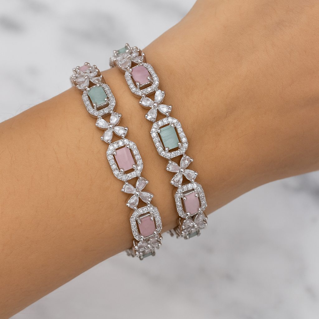 Elegant bracelet with gemstones on a wrist against a marble background. Brand: Oplique By Vineeta