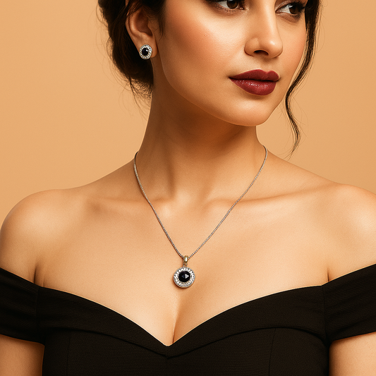 A Woman wearing a black off-shoulder top with a necklace and earrings against a beige background. Brand: oplique By Vineeta